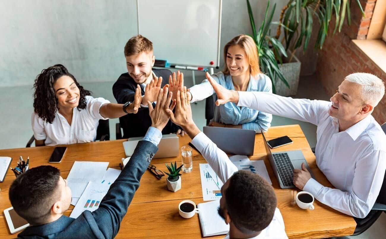 happy-coworkers-giving-high-five-celebrating-business-success-sitting-in-office-2B7JG4G-transformed (1) (1)